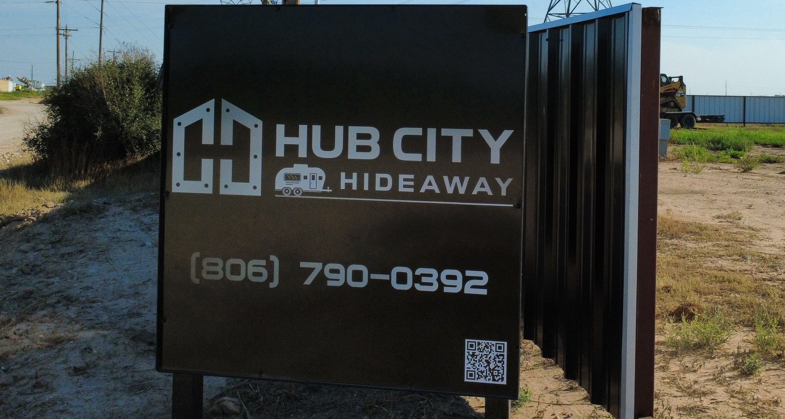 The modern black Hub City Hideaway sign with the logo and phone number.